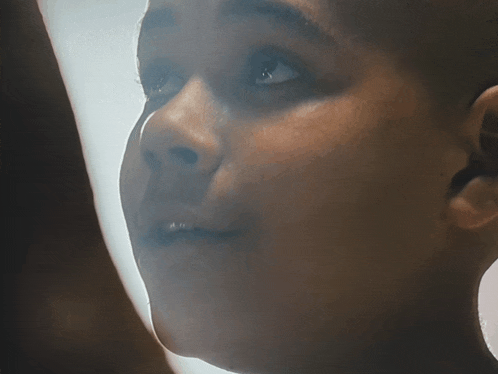 a close up of a person 's face with a light behind them