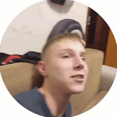 a young man wearing a baseball cap is sitting on a couch .