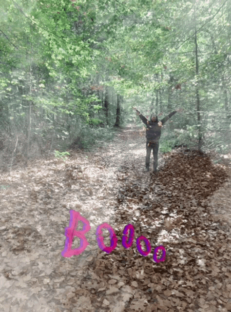a person in a forest with the word booo written in pink