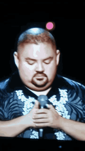 a man with a beard holds a microphone in his hands