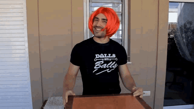 a man wearing an orange wig is wearing a shirt that says dolls with balls
