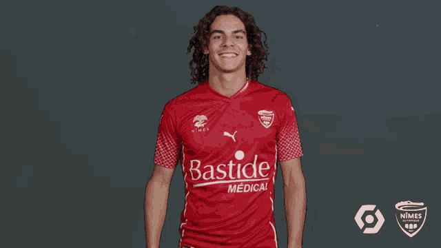 a man wearing a red shirt that says bastide medical on it