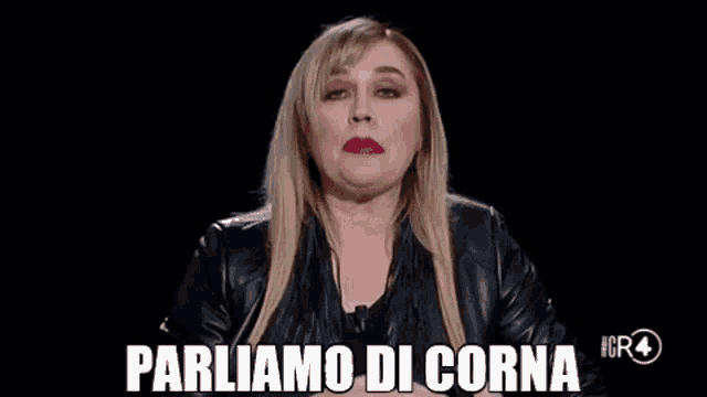 a woman in a leather jacket is making a funny face and saying `` parliamo di corna '' .