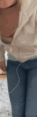a woman wearing headphones and a white shirt has her shirt open