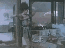 a woman is standing in a kitchen with a tray of food on the counter