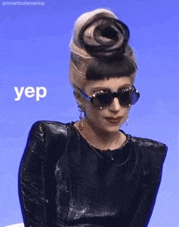 a woman wearing sunglasses and a bun with the word yep on it .