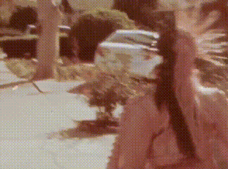 a blurred image of a person walking down a sidewalk next to a car .