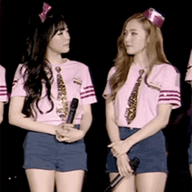 two girls wearing pink shirts and ties standing next to each other