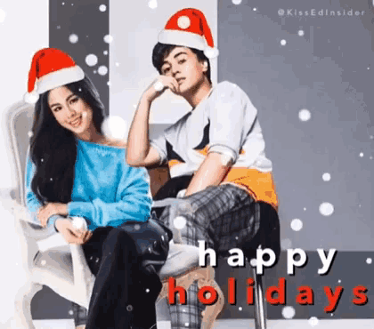 a man and a woman wearing santa hats are sitting next to each other with the words happy holidays written below them
