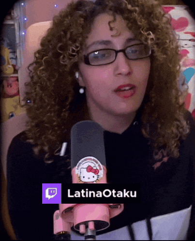 a woman with curly hair is wearing glasses and holding a pink hello kitty microphone with the name latinaotaku on the bottom