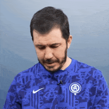 a man with a beard is wearing a blue shirt that says nike on it