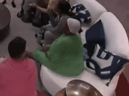 a group of people are sitting on a white couch in a living room .