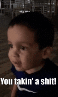 a little boy is sitting on the floor and making a funny face .