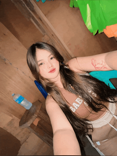 a woman taking a selfie with a bottle of water behind her