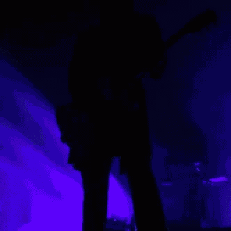 a man in a tuxedo is playing a guitar