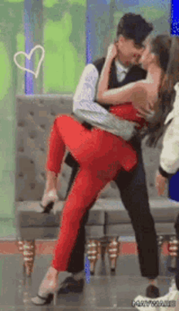 a man is holding a woman in his arms and kissing her