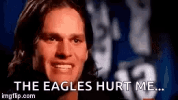 a man is smiling in front of a sign that says the eagles hurt me ...