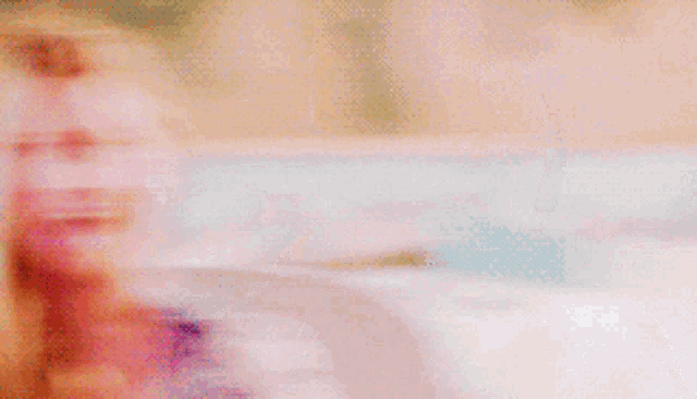 a blurry picture of a woman with long blonde hair making a funny face