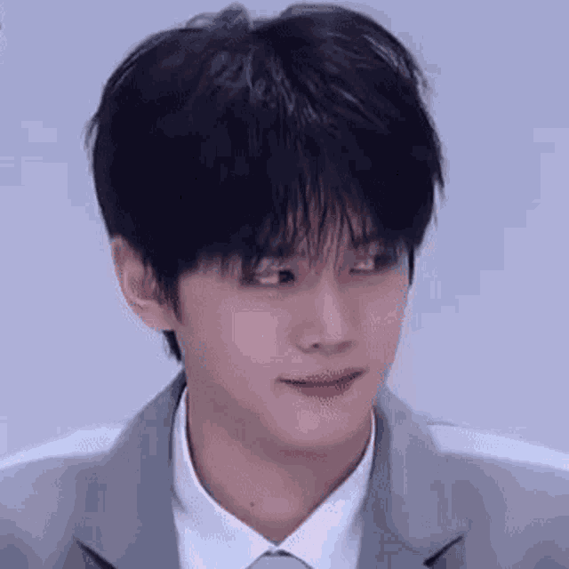 a close up of a young man in a suit and tie making a funny face .