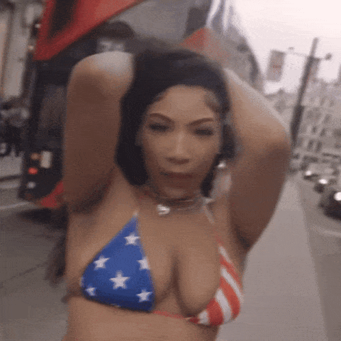 a woman in an american flag bikini stands on a street