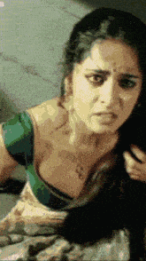 a pixelated image of a woman with a green blouse