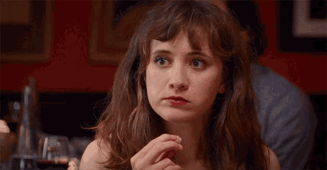 a woman with red lips is sitting at a table