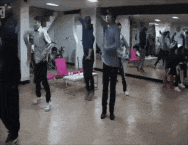 a group of people are dancing in a room with a sign that says ' k ' on it