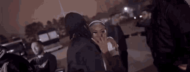 a man is hugging a woman in a parking lot .