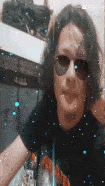 a man wearing sunglasses and a black shirt has a capcut watermark on the bottom right