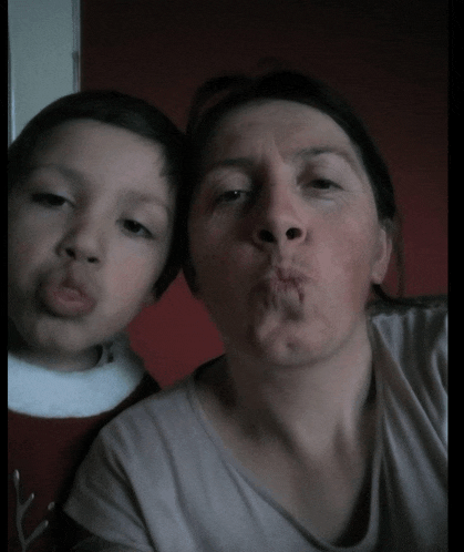 a woman and child are making funny faces for the camera