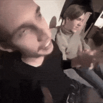 two young men are sitting next to each other on a couch .