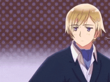 a boy with blonde hair and blue eyes is wearing a suit and tie