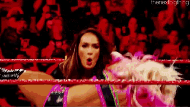 a woman is wrestling another woman in a ring .