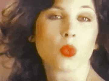 a woman is blowing a kiss with red lips .