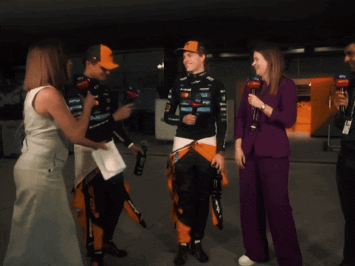 a man in a mclaren uniform is talking to a woman