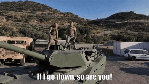 two soldiers standing on top of a tank with the words if i go down so are you