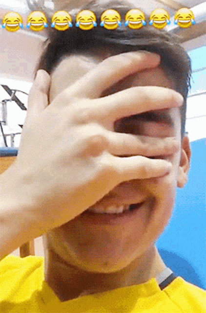 a person covering their face with their hand with a bunch of laughing emojis behind them