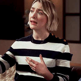 a woman wearing a black and white striped sweater is talking
