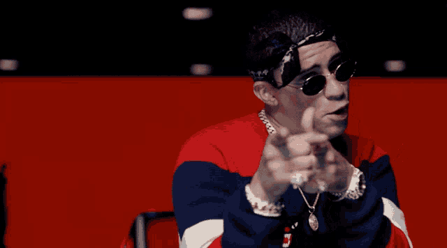 a man wearing sunglasses and a bandana is pointing
