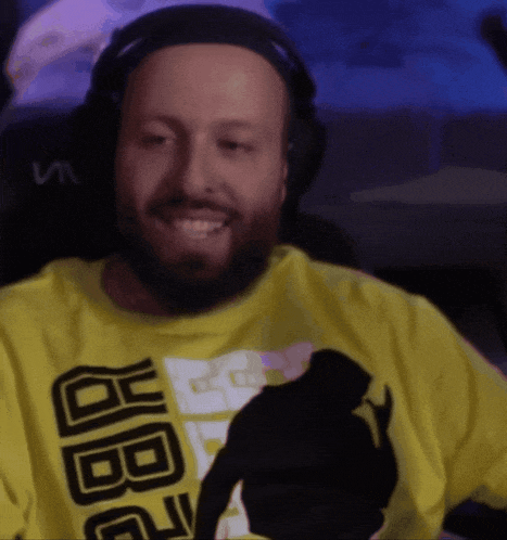 a man with a beard wearing headphones and a yellow shirt that says jbg on it