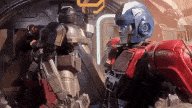 a couple of robots standing next to each other in a room .