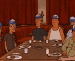 a group of people are sitting around a table with plates and cups