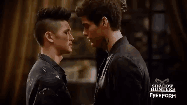 two men are standing next to each other and looking at each other in a room .