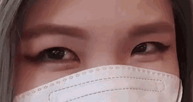 a close up of a woman wearing a mask .