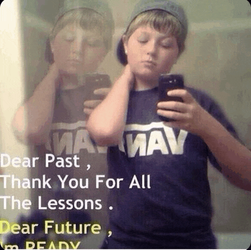 a boy taking a picture of himself in a mirror while wearing a shirt that says mav