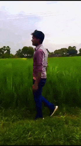 a man is walking across a grassy field .