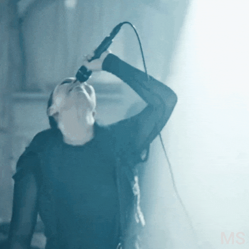 a woman singing into a microphone with the word ms on the bottom
