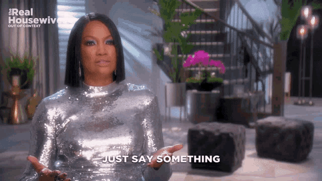 a woman in a silver sequined dress is saying just say something