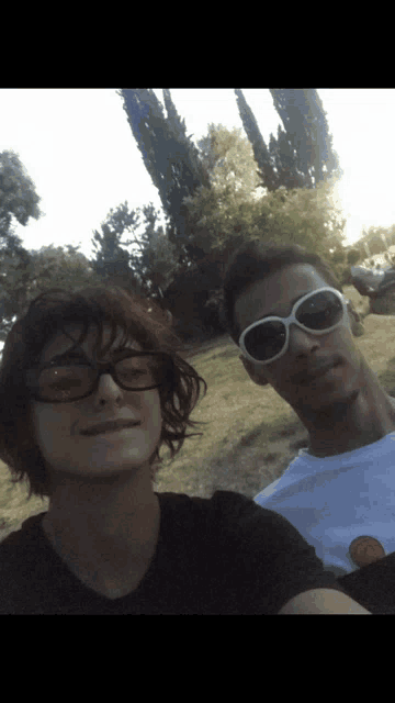 a man and a woman wearing sunglasses pose for a picture together