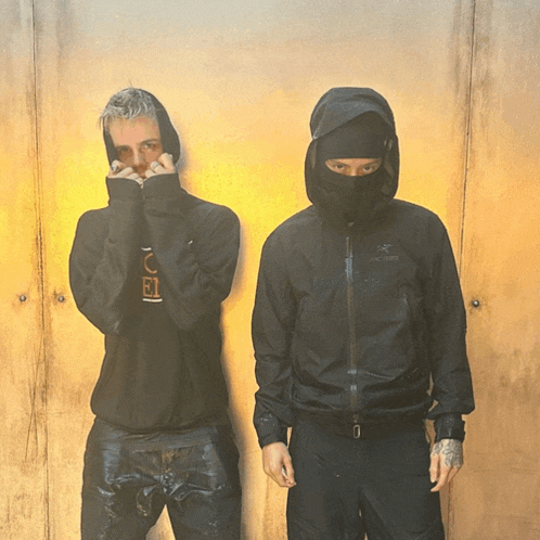 two men standing next to each other one wearing a jacket that says arcteryx